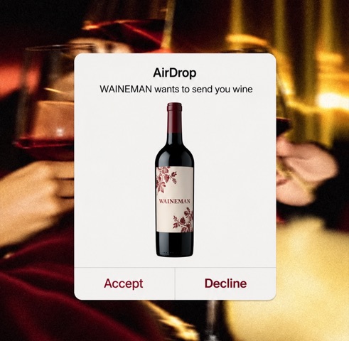 Een AirDrop-melding: WAINEMAN wil je wijn sturen, met een fles WAINEMAN-wijn en de knoppen Accept en Decline